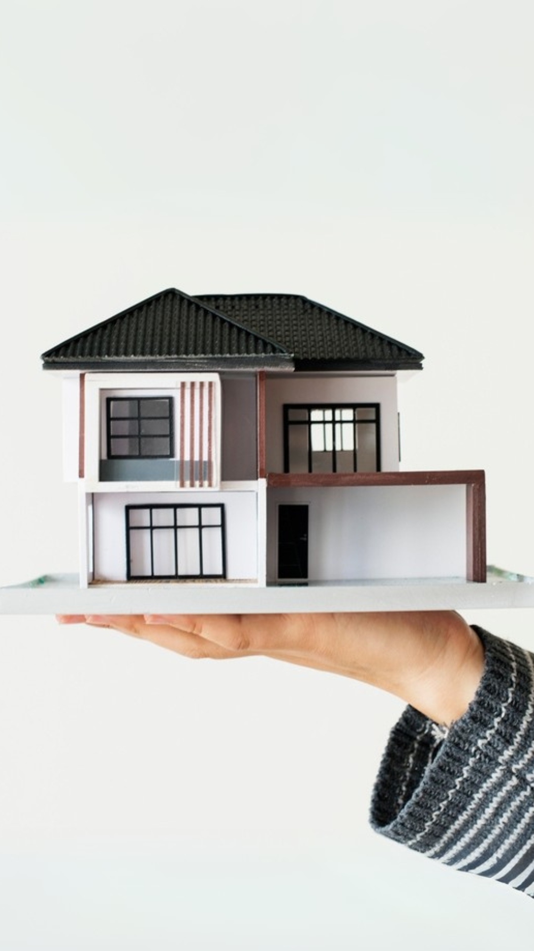 Estate agent holding model house in their hand